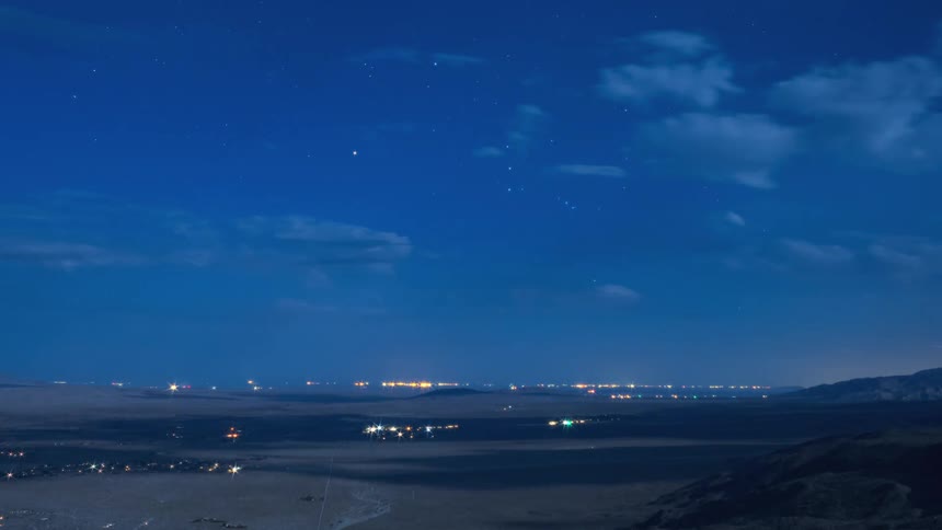 A time lapse of cars driving across a landscape and clouds passing over head