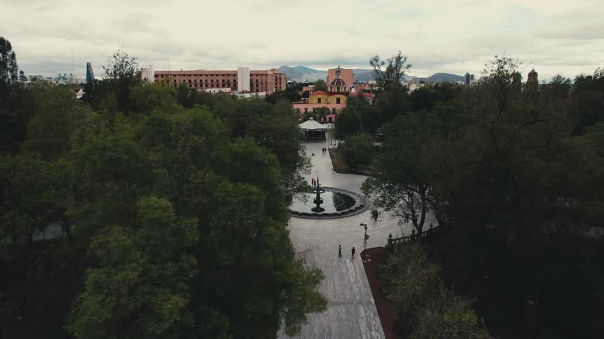 People walk through the park by the city