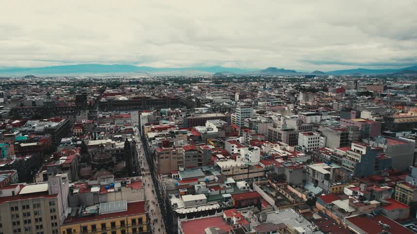 An aerial view of buildings in a city and cars driving down streets