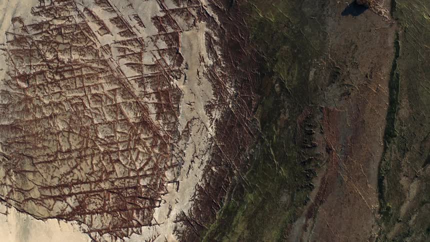 An aerial view of terrain with sand and soil