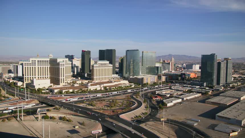 Aerial view of a city with tall buildings and traffic on the roads and mountains in the distance