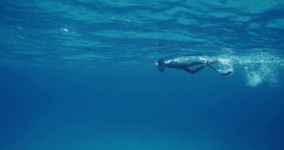 A man is snorkeling in the ocean during the daytime