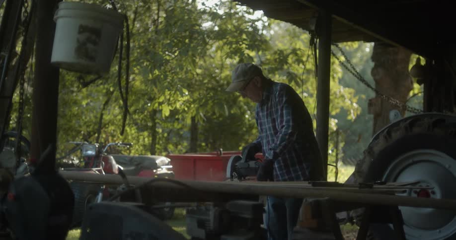 A man is outside working with a power saw