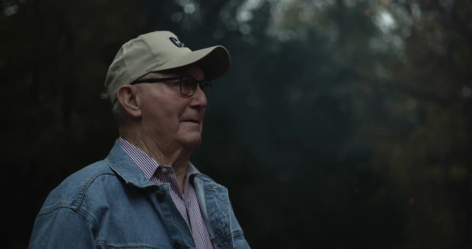 A man watches the smoke and sparks from the fire