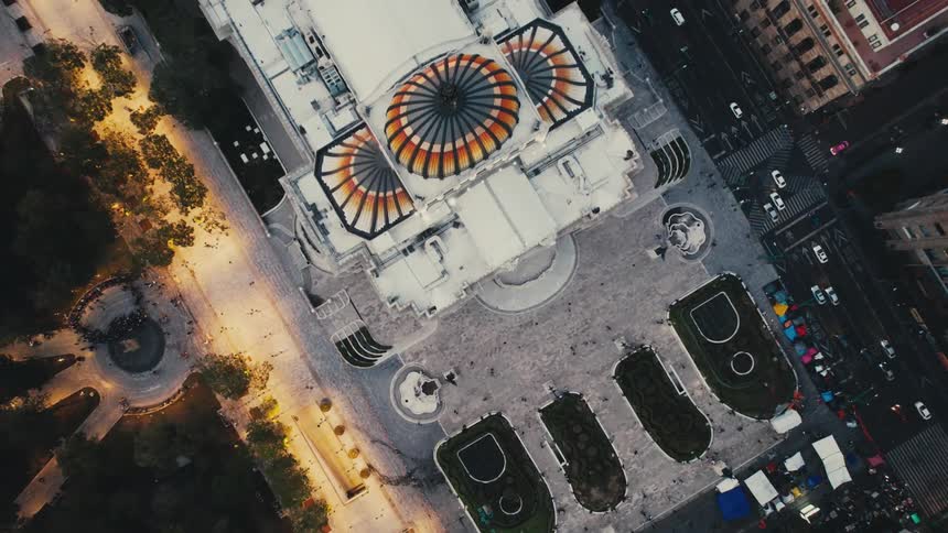 An aerial view looking straight down onto a large cathedral in a city with traffic flowing in the daytime