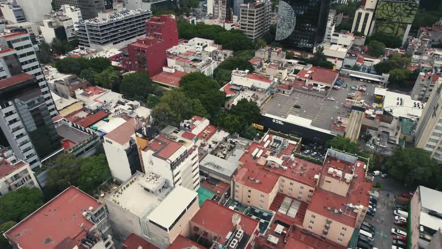 An aerial view of buildings and sky scrapers and vehicles driving in a city