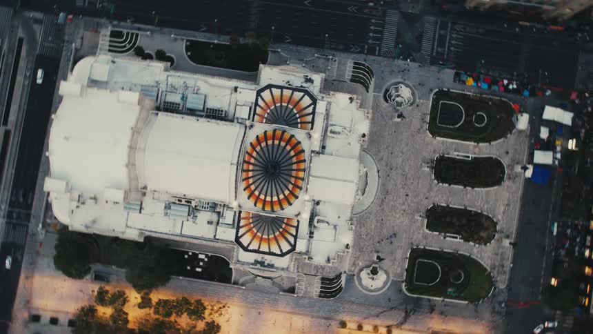 Colorful orange and black colored roof roof details decorate building bordered by streets with parked cars