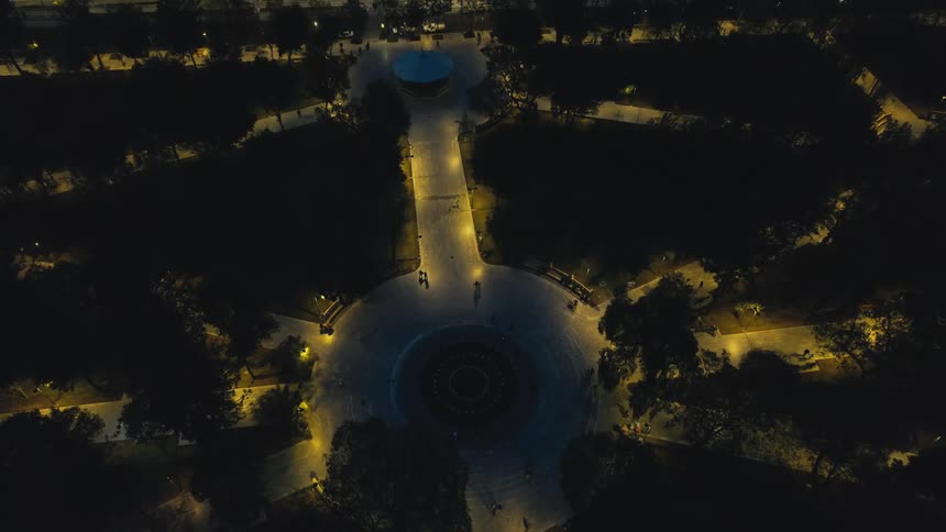 Areial view of a round public walkway busy with people out at night