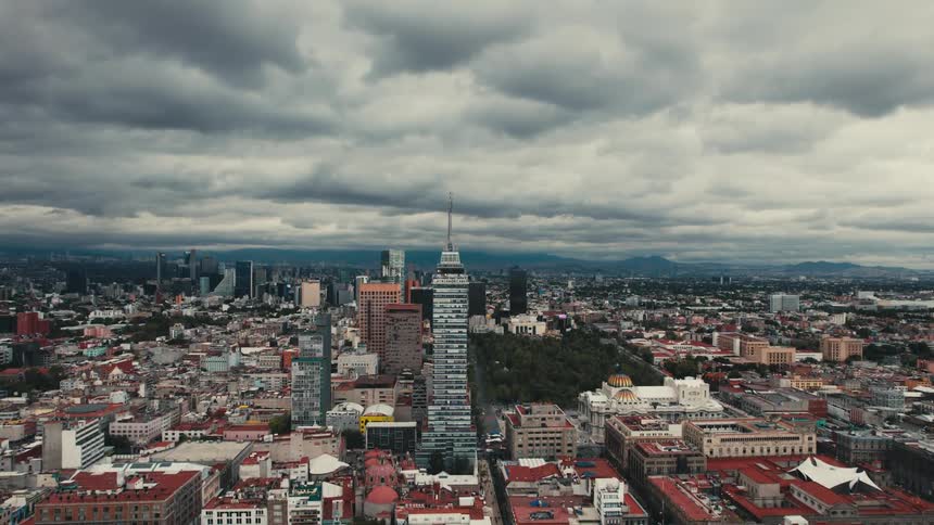 Park sits in middle of city stretching to misty mountain under overcast sky