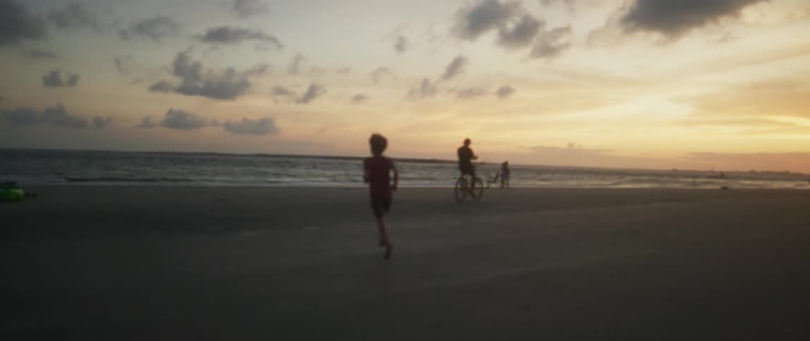 Child running towards water at beach