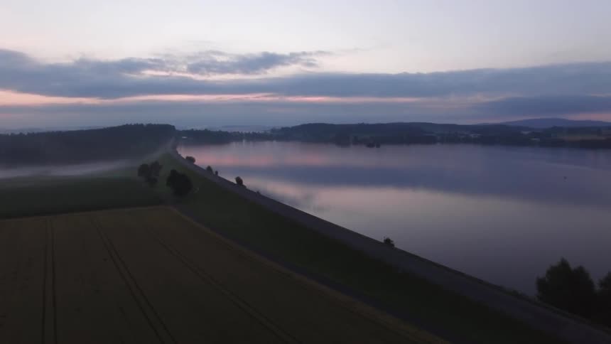 A sunrise is reflected over a lake