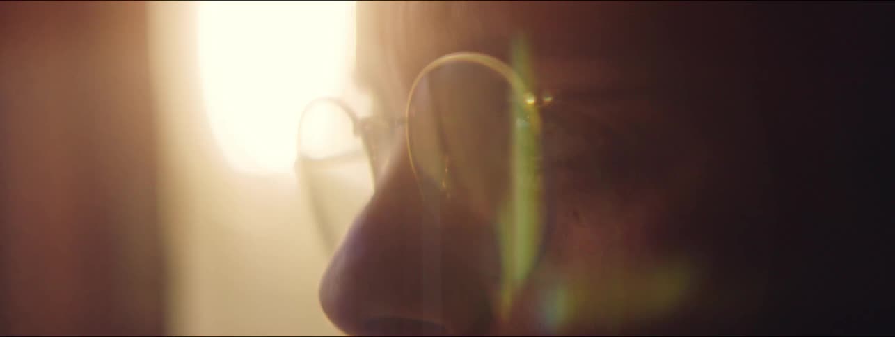 A close up of a woman wearing glasses while sending audio message