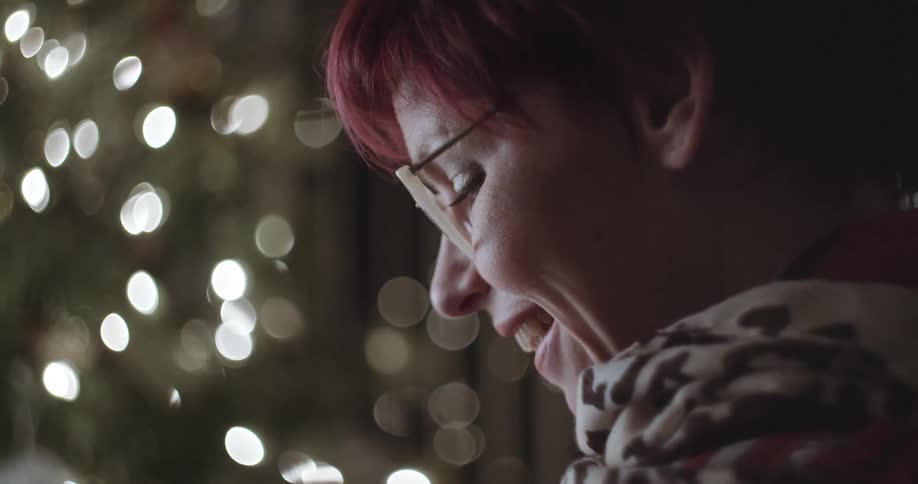 A woman with red hair is looking down and smiling