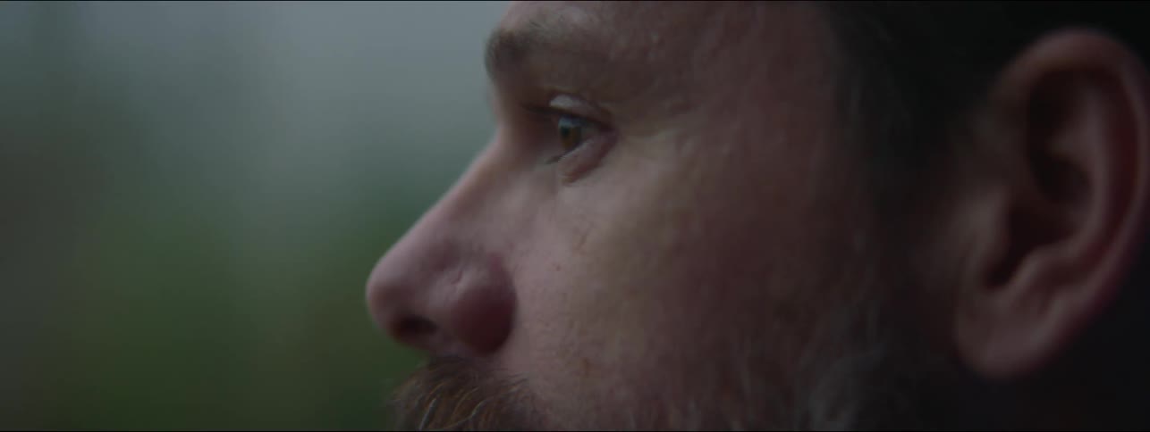 Close up of the face of a bearded man standing outdoors