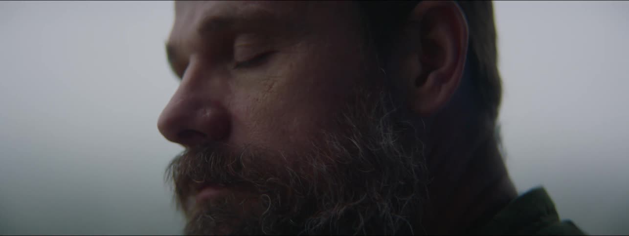 Middle aged man with beard opens his eyes and looks around