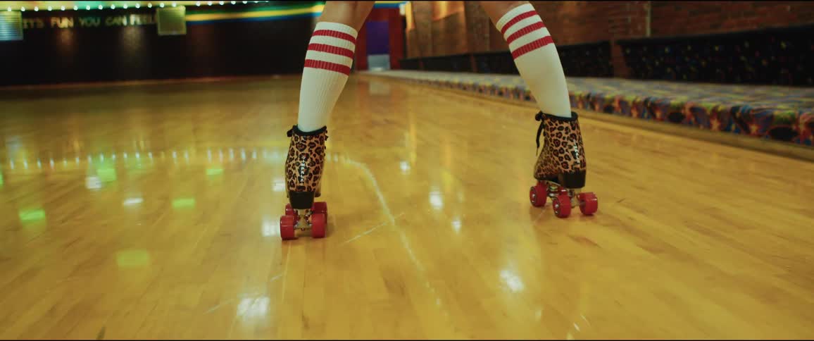 A person is roller skating indoors under the flashing lights
