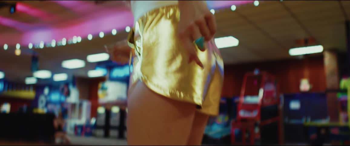 A woman laughs as she skates in a roller rink