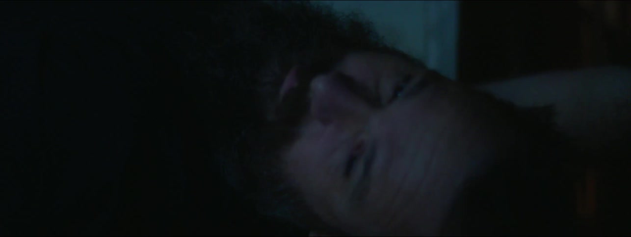 A man lays down in the dark to rest