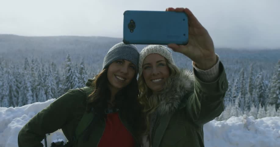 Two women stand together and take a photo
