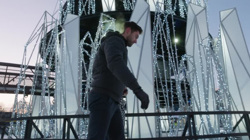 A man and a woman ice skating in a skating rink
