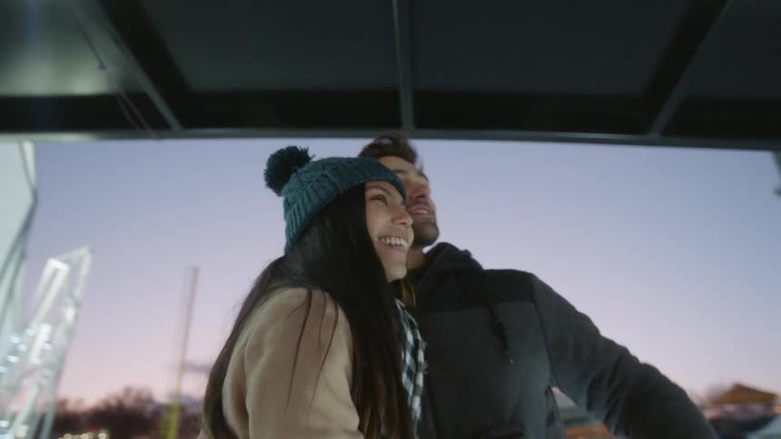A man and woman hug and talk together on the ice rink