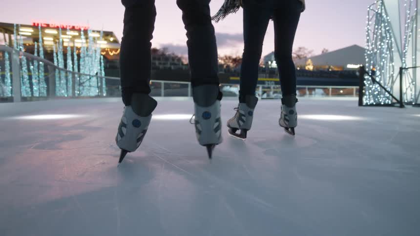Two people are ice skating together at dawn