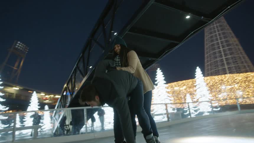 Woman helps man who has fallen on ice skates up