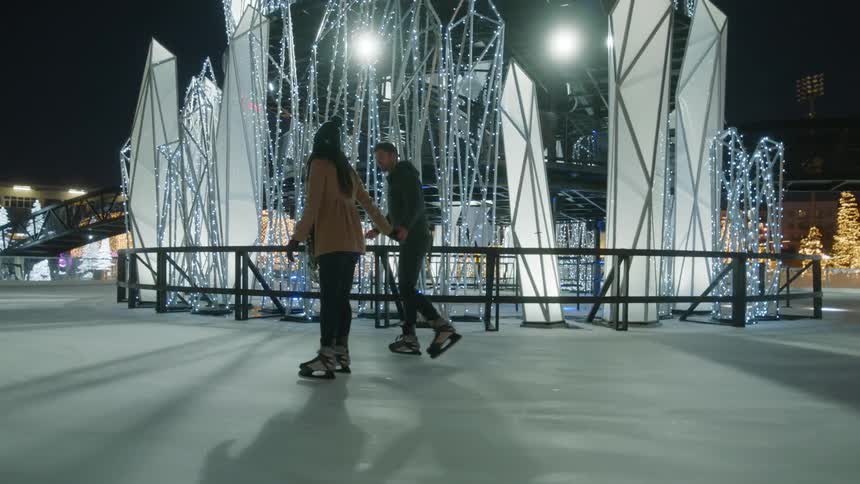 A woman and man are ice skating together