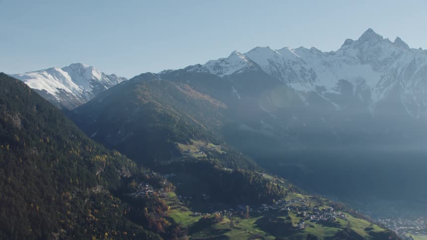 A town next to a snow capped mountain range during the day