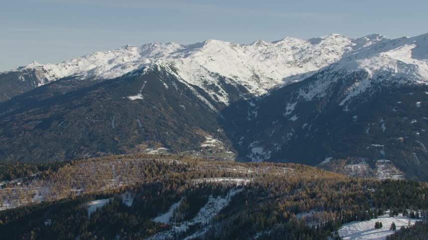 An aerial view of a mountain range with snow on it