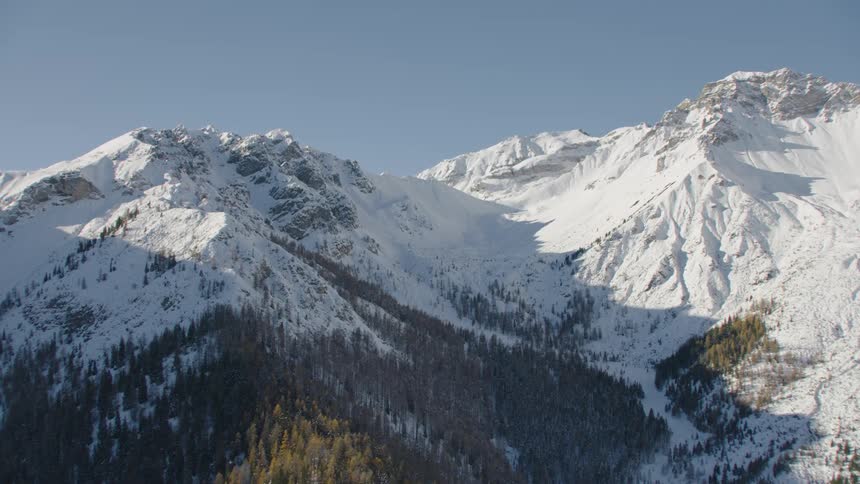 An aerial view of a mountain range covered in snow