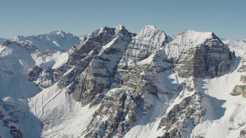 An aerial view of a mountain range with snow on it