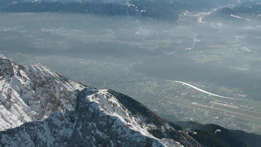 An aerial view of a mountain range with snow on it