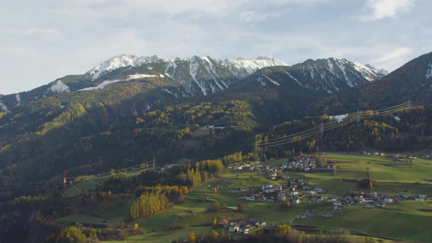 Aerial view of a small town near the snow covered peaks of a mountain range at morning