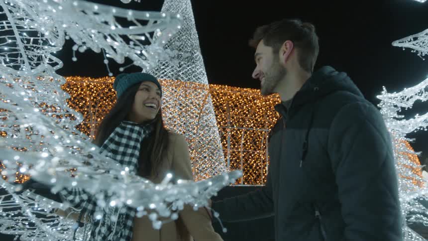 A man comes up behind a woman and surprises her