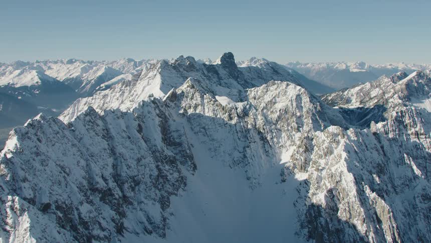 A mountain range covered in snow in the wilderness on a clear day