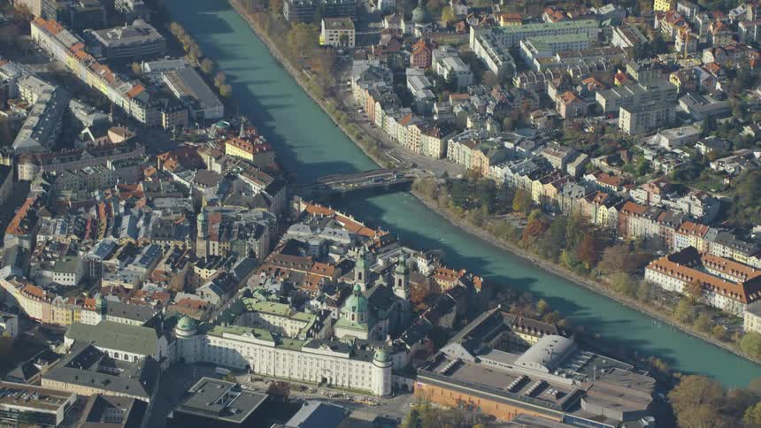 A turquoise river separates a neighborhood from downtown