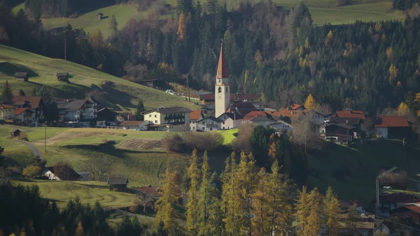 An aerial view of a village with a church in the center