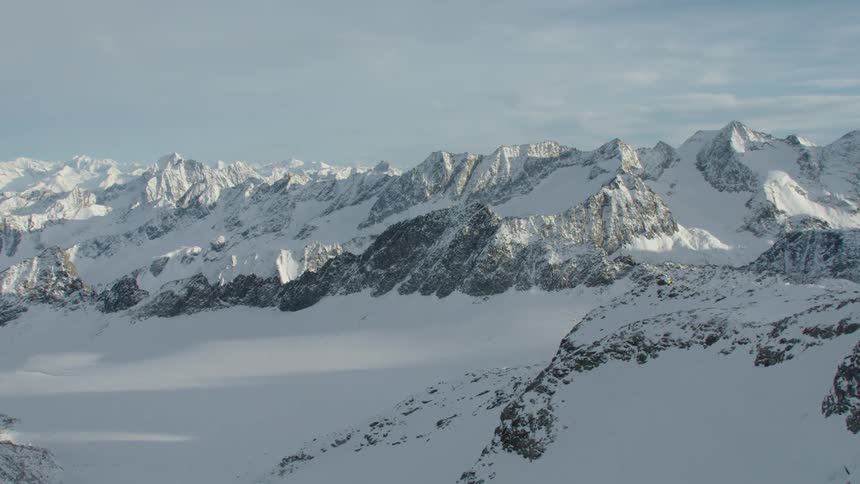 An aerial view of a mountain range covered in snow