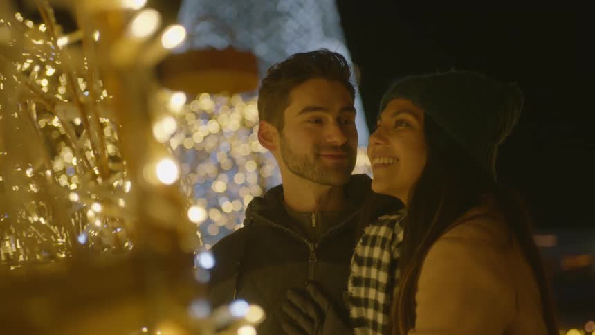 A couple looks at christmas decoration lights together