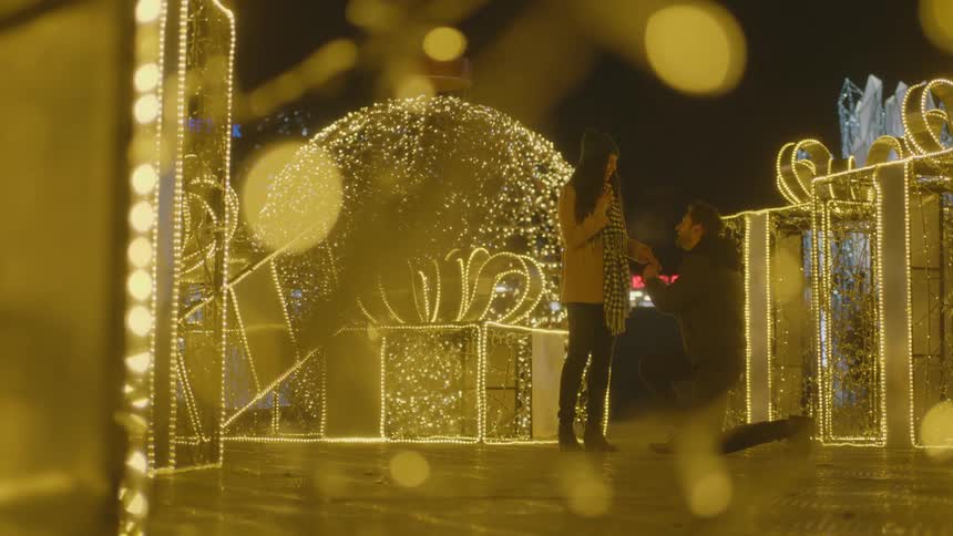 A man is proposing to his girlfriend outdoors