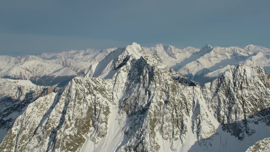 Aerial view of the snow covered slopes and cliffs on the peaks of a mountain range