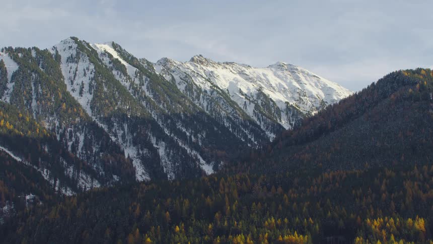 An aerial view of a mountain range with snow on it