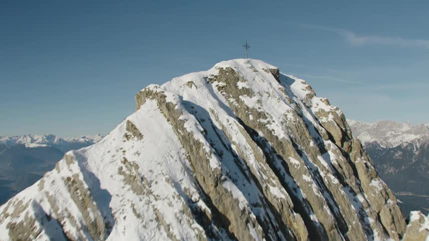 Aerial view of a small town in a valley between the snow covered mountain peaks