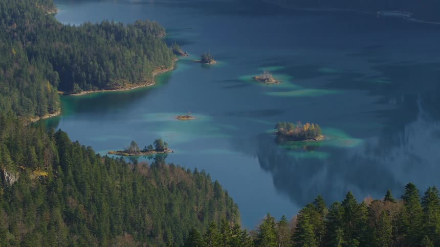 The mountains near the shore are covered with trees