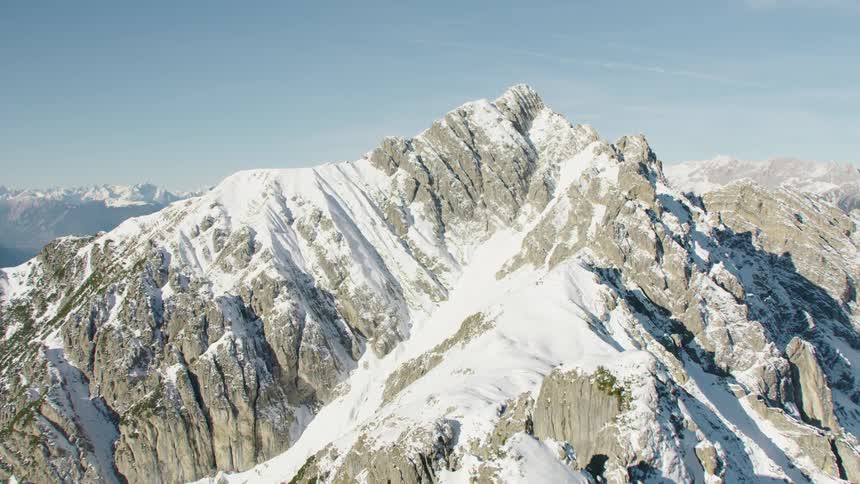 An aerial view of a mountain range with snow