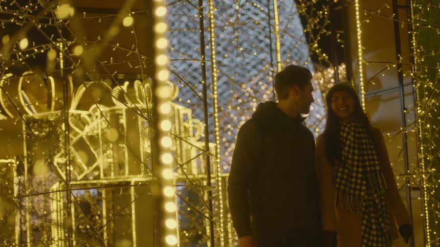 A couple walk through a large lighted outdoor display