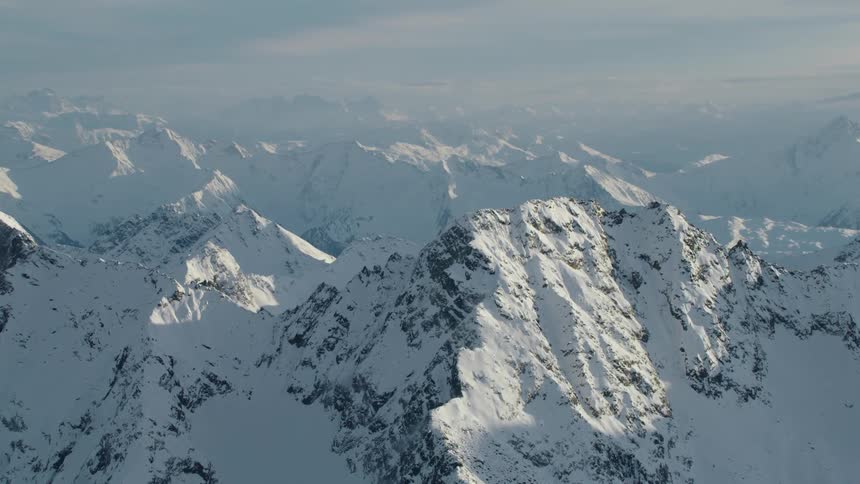 An aerial view of a mountain range with snow on it