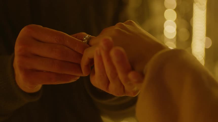 A man proposes to a woman with a large diamond ring