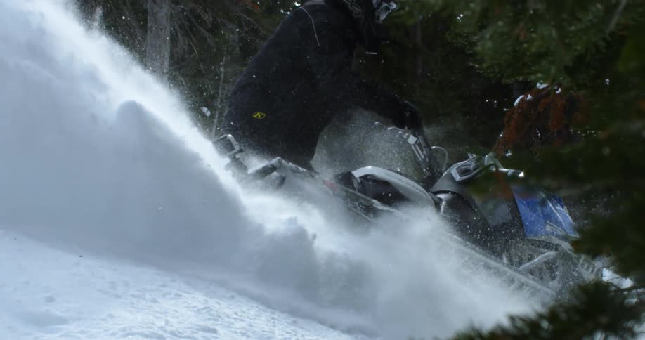 A person makes a sharp turn on a snowmobile